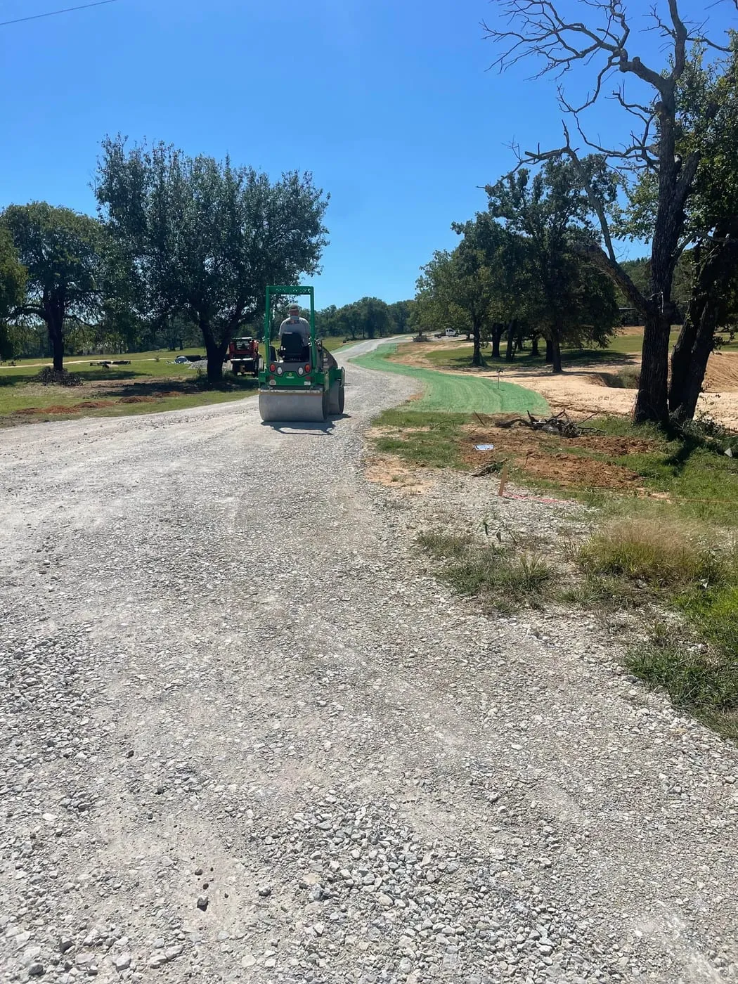 DEVCO equipment grading a new gravel road on a Texas property